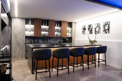 a kitchen with a bar with blue bar stools at Provenza luxury parque Lleras D'house, happy house in Medellín