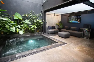 a swimming pool in the middle of a room with plants at Provenza luxury parque Lleras D'house, happy house in Medellín