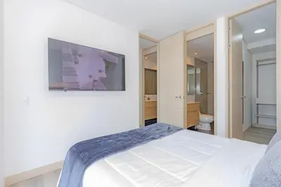 a bedroom with a bed and a tv on the wall at El Poblado Prime Location Medellin Apt in Medellín