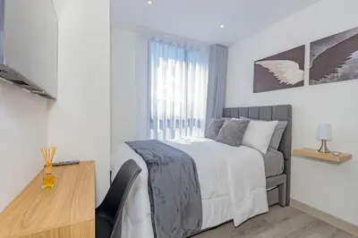 a bedroom with a bed and a desk and a window at El Poblado Prime Location Medellin Apt in Medellín