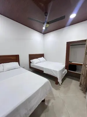 a bedroom with two beds and a ceiling fan at Apartahotel María Antonia in Doradal