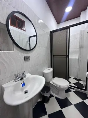 a bathroom with a sink and a toilet and a mirror at Apartahotel María Antonia in Doradal