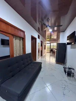 a living room with a black couch and a tv at Apartahotel María Antonia in Doradal
