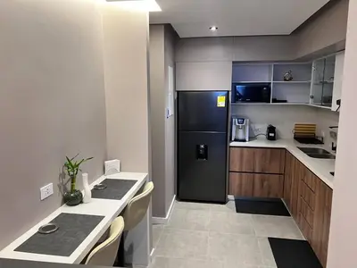 a kitchen with a black refrigerator and a table at Medellín Skyview penthouse in Medellín