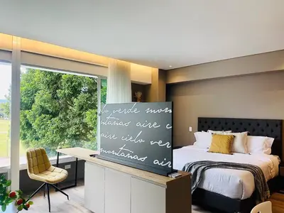 a bedroom with a bed and a desk and a window at Prime Stays L55 in San Antonio de Pereira