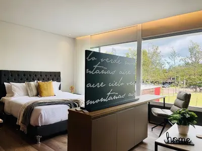 a bedroom with a bed and a desk and a window at Prime Stays L55 in San Antonio de Pereira