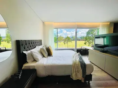 a bedroom with a large bed and a flat screen tv at Prime Stays L55 in San Antonio de Pereira