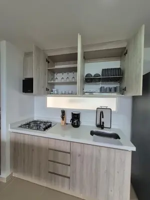 a kitchen with wooden cabinets and a counter top at Apartasol Moderno bajo el Sol de Santa Fe in Santa Fe de Antioquia