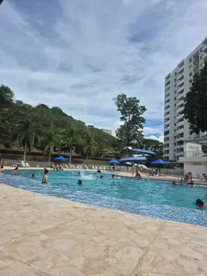 a large swimming pool with people in the water at Apartasol Moderno bajo el Sol de Santa Fe in Santa Fe de Antioquia