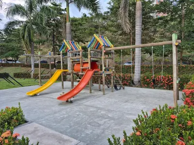 a playground with two slides and a swing at Apartasol Moderno bajo el Sol de Santa Fe in Santa Fe de Antioquia