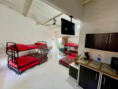 a room with four bunk beds and a flat screen tv at Cabaña en Santorini in Puerto Triunfo