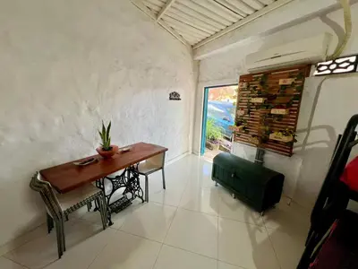 a small dining room with a table and a window at Cabaña en Santorini in Puerto Triunfo