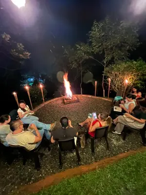 a group of people sitting around a fire at night at Playa Primavera in San Carlos