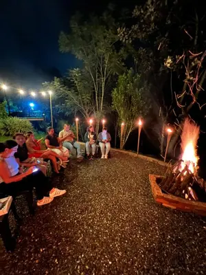 a group of people sitting around a fire at night at Playa Primavera in San Carlos