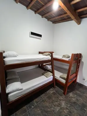 a room with three bunk beds and a ceiling at Playa Primavera in San Carlos