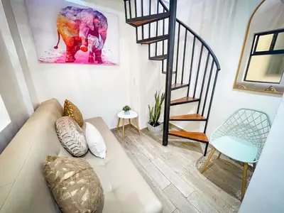 a living room with a couch and a staircase at DUo Nido in Medellín