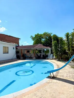 a swimming pool with a hose in front of a house at Finca De Lujo En Copacabana Antioquia in Copacabana