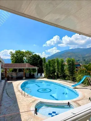 a view of a swimming pool with mountains in the background at Finca De Lujo En Copacabana Antioquia in Copacabana