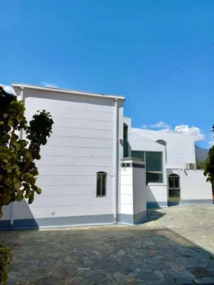 a white building with a garage in front of it at Finca De Lujo En Copacabana Antioquia in Copacabana