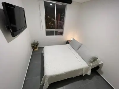 a bedroom with a bed and a flat screen tv at Amplio y acogedor Apartamento en Sabaneta cerca al parque in Sabaneta
