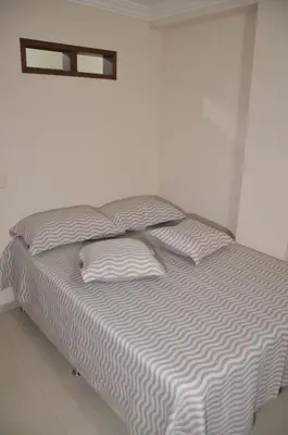 a bed in a white room with two pillows at Apto Amoblado 3 Hab Cerca al Atanasio in Medellín