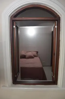 a mirror reflecting a bed in a room at Apto Amoblado 3 Hab Cerca al Atanasio in Medellín
