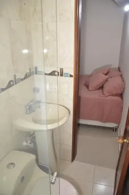 a bathroom with a sink and a toilet and a bed at Apto Amoblado 3 Hab Cerca al Atanasio in Medellín