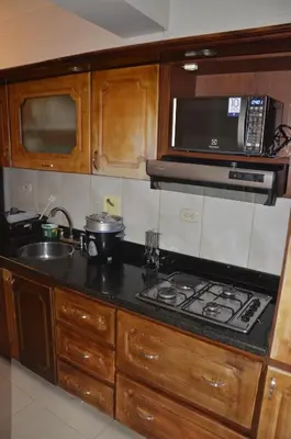 a kitchen with a stove and a sink and a microwave at Apto Amoblado 3 Hab Cerca al Atanasio in Medellín