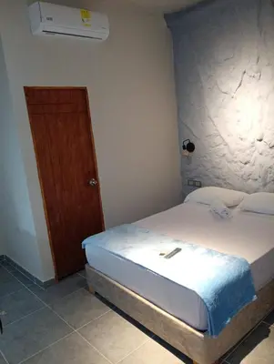 a bedroom with a bed and a wooden door at Hotel Kyros by 70 in Medellín