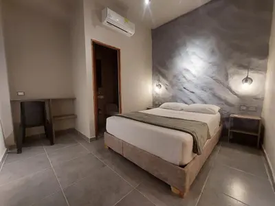 a bedroom with a large bed and a desk at Hotel Kyros by 70 in Medellín