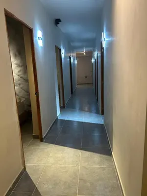 a hallway with a long corridor with doors and a tile floor at Hotel Kyros by 70 in Medellín