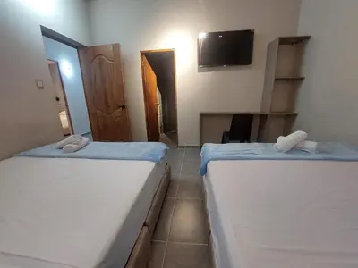two beds in a room with a tv on the wall at Hotel Kyros by 70 in Medellín