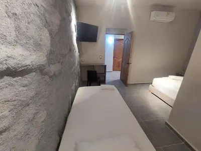 a white bench in a room with a bedroom at Hotel Kyros by 70 in Medellín