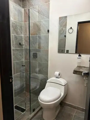 a bathroom with a toilet and a glass shower at Hotel Kyros by 70 in Medellín