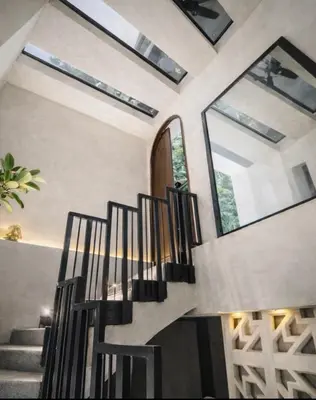 a spiral staircase in a home with windows at CEMNTUS VILLA , Rooftop Jacuzzi, 9BR, VIP Service in Medellín