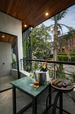 a table with a bucket and a glass of wine on a balcony at CEMNTUS VILLA , Rooftop Jacuzzi, 9BR, VIP Service in Medellín