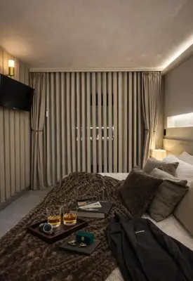 a hotel room with a bed with two drinks on it at CEMNTUS VILLA , Rooftop Jacuzzi, 9BR, VIP Service in Medellín