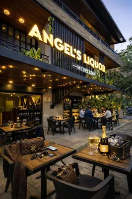 a restaurant with tables and chairs in front of a building at CEMNTUS VILLA , Rooftop Jacuzzi, 9BR, VIP Service in Medellín