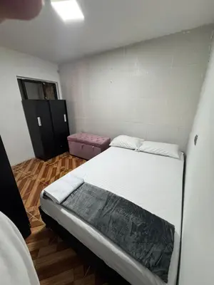 a small room with a bed and a pink stool at House with Terrace San Javier Comuna 13 in Medellín