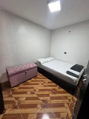 a small room with a bed and a pink ottoman at House with Terrace San Javier Comuna 13 in Medellín