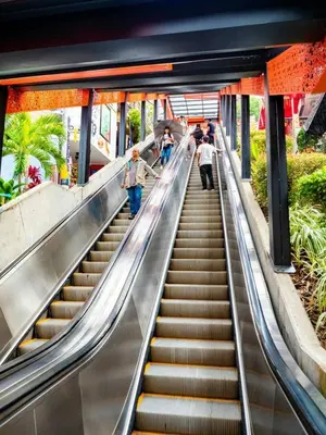 an escalator in a building with people walking up it at House with Terrace San Javier Comuna 13 in Medellín