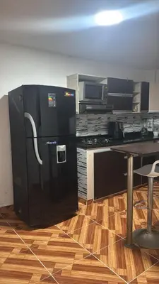 a black refrigerator in a kitchen with a table at House with Terrace San Javier Comuna 13 in Medellín
