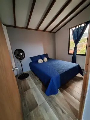 a bedroom with a blue bed and a window at Baires Loft Apatartamentos in Medellín