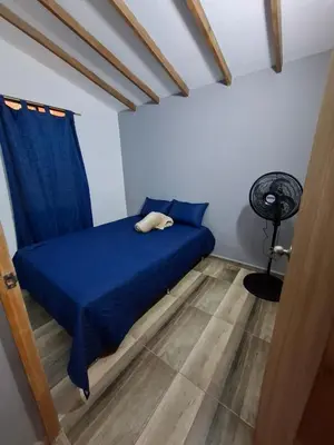 a bedroom with a blue bed and a fan at Baires Loft Apatartamentos in Medellín