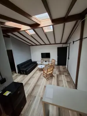 a living room with a black couch and a tv at Baires Loft Apatartamentos in Medellín