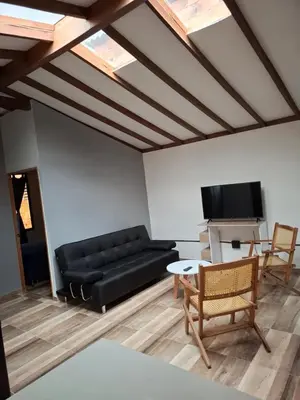 a living room with a black couch and a tv at Baires Loft Apatartamentos in Medellín