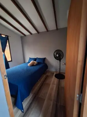 a bedroom with a blue bed and a fan at Baires Loft Apatartamentos in Medellín