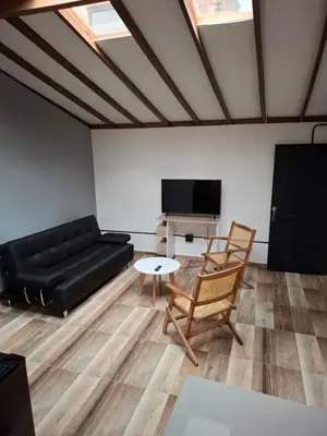 a living room with a black couch and a table at Baires Loft Apatartamentos in Medellín