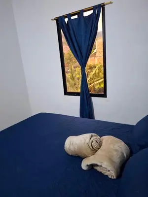 a bed with a blue sheets and a window at Baires Loft Apatartamentos in Medellín