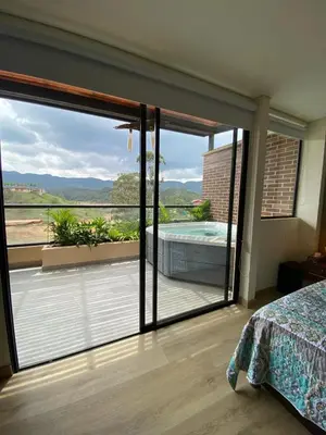 a bedroom with a sliding glass door to a balcony at San Telmo Guatape Apto con Jacuzzy in Guatapé